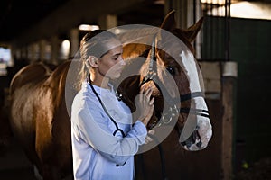 Confident female vet stroking horse