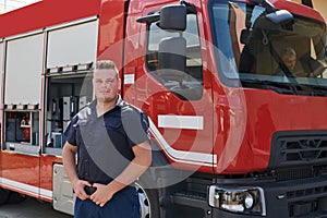 A confident firefighter strikes a pose in front of a modern firetruck, exuding pride, strength, and preparedness for