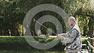 Confident fisherman preparing a rod for fishing at the pond