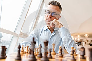 Confident focused business man playing chess