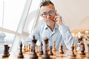 Confident focused business man playing chess