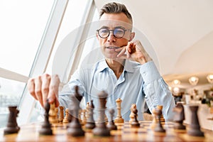 Confident focused business man playing chess