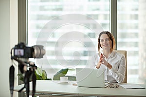 Confident focused businesswoman vlogger talking to camera filmin