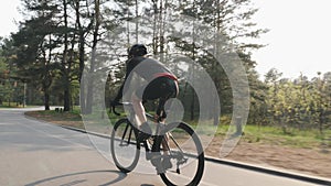 Confident focused cyclist pedaling on bicycle in the park. Road cycling training. Cycling concept.