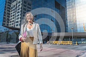 Confident, focused and powerful business woman walking in the street. Female corporate professional going or leaving the