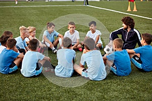 Confident football trainer teach, instruct kids boys