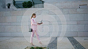 Confident freelancer working go holding laptop. Woman walking looking computer