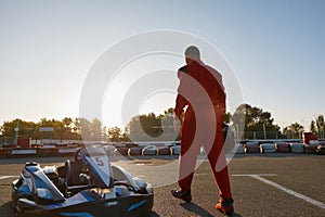 Confident go-kart driver walking to car before race at starting line