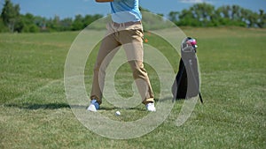 Confident golf player teeing off ball, rejoicing successful shot and gesturing