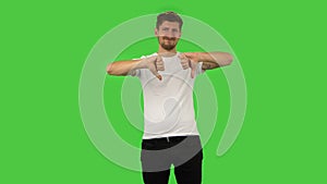 Confident guy is showing thumbs down gesture. Green screen