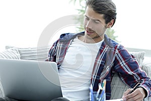 Confident guy working with laptop at home.