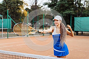 Confident handling of the ball when playing on the net. An attractive, beautiful tennis player practicing exercises to improve her