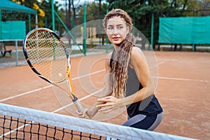 Confident handling of the ball when playing on the net. An attractive, beautiful tennis player practicing exercises to improve her