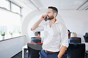 Confident handsome businessman talking on the phone in office