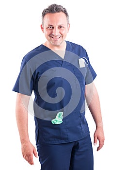 Confident and handsome doctor posing wearing blue scrubs