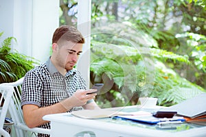 Confident handsome young man using smart phone.