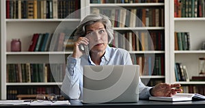 Confident happy mature senior business woman speaking on mobile phone