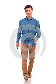 Confident happy young casual man walking forward