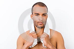 Confident harsh young mulatto nude man is standing on the pure w