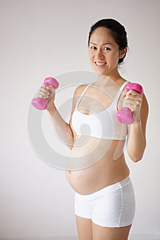 Confident healthy Asian Chinese pregnant mother keeping healthy