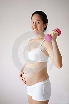 Confident healthy Asian Chinese pregnant mother keeping healthy
