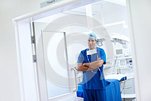 Confident in his walkspace. A handsome male doctor standing in the doorway of his operating theatre.