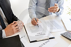 Confident insurance agent broker man holding document and present pointing showing an insurance policy contract form to client