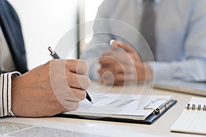 Confident insurance agent broker man holding document and present pointing showing an insurance policy contract form to client