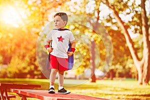 Confident little child boy plays superhero