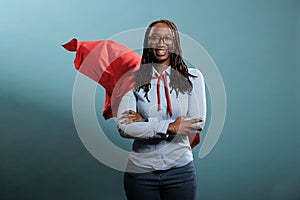 Confident looking mighty powerful young adult person wearing superhero costume on blue background