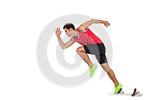 Confident male athlete running from starting blocks