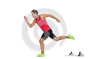 Confident male athlete running from starting blocks