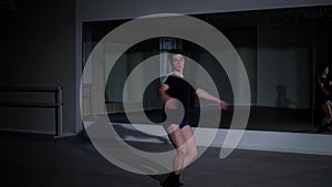 Confident male ballet dancer jumping spinning and smiling looking at camera sitting down. Wide shot portrait of talented