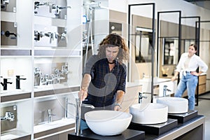 Confident male customer choosing bathroom sink in hardware store