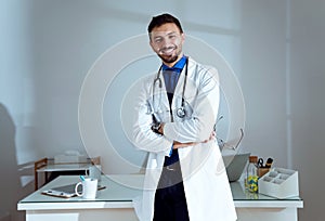 Confident male doctor smiling and looking at camera in the office.