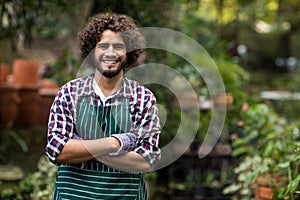 Confident male gardener standing at greenhouse