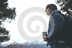 Confident male hiker with backpack and thermos mug, dreamily looking away while hiking in mountains of Sierra de Cazorla