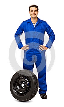 Confident Male Mechanic With Spare Tire