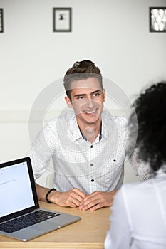 Confident male millennial applicant smiling at job interview, ve