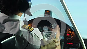 Confident male pilot operating airplane and refusing alcoholic drink in cockpit