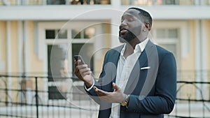 Confident male professional having video chat outside. Man standing outdoors