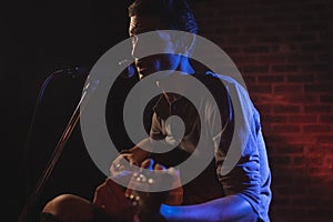 Confident male singer playing guitar