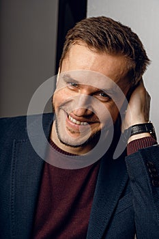 Confident male smiling. Business man portrait on dark background. Handsome young man weared suit in studio