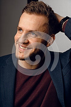 Confident male smiling. Business man portrait on dark background. Handsome young man weared suit in studio