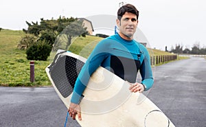 Confident Male Surfer with Board on Coastal Path