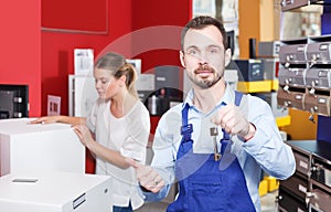 Confident man proffering keys to young client