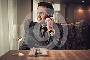 Confident man with smart phone in restaurant.