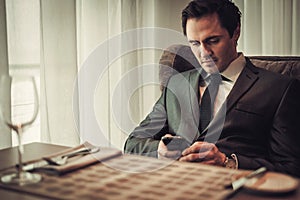 Confident man with smart phone in restaurant.