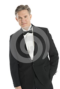 Confident Man In Tuxedo Standing Against White Background