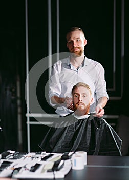 Confident man visiting hairstylist in barber shop.